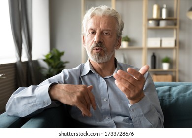 Confident Hoary Middle Aged Handsome Man Looking At Camera, Holding Business Talk With Clients Partners Online. Web Camera View Mature Senior Grandfather Chatting With Friends Family Via Video Call.