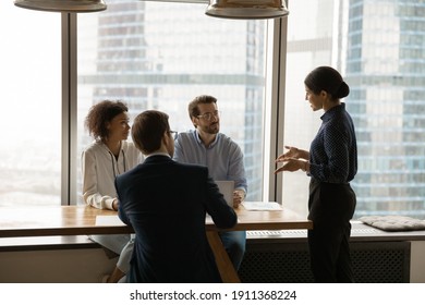 Confident Indian Female Business Coach Provide Professional Training To Multiethnic Corporate Staff. Young Hindu Woman Team Leader Explain Sales Strategy To Attentive Employees On Briefing In Office