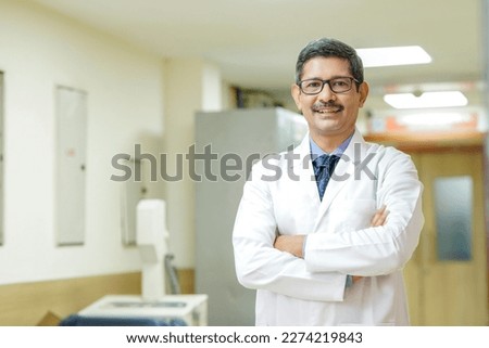 Confident Indian male doctor standing at hospital.