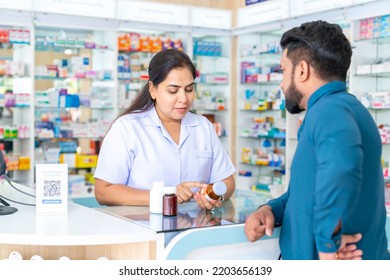 Confident Indian Woman Pharmacist Medication Recommendation About Medicine, Drugs And Supplements To Male Patient Customer In Modern Drugstore. Medical Pharmacy And Healthcare Providers Concept.