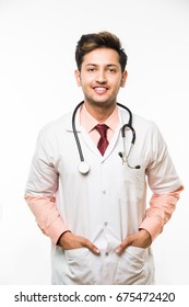 Confident Indian/Asian young Male Doctor with stethoscope OR hands folded, standing isolated over white background