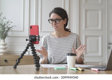 Confident Italian Woman Economist Counselor Recording Video Stream Online Consultation For Group And Individuals, Tutor Lady Using Phone On Tripod For Video Chat Sitting At Home. Business Blog Concept