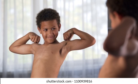 Confident Kid Looking At His Muscles In Mirror Imagining That He Is Super Hero