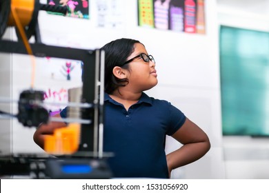 A Confident Latino Student Thinking About Her 3D Project In A After School Program Focusing On STEM.