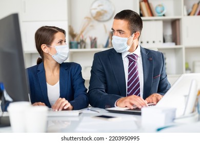 Confident Male And Female Business Partners Wearing Protective Masks Working In Office. New Standards Due To Coronavirus Outbreak