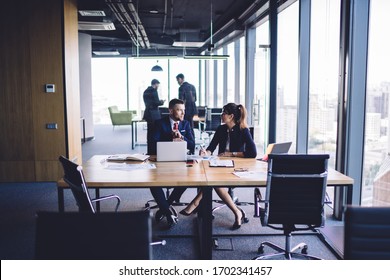 Confident male and female colleagues analyzing information during cooperation working process, formally dressed executive managers communicating about report during together business experience