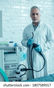 Confident Male Medical Worker Standing Near The Modern Apparatus With Endoscope In His Hands