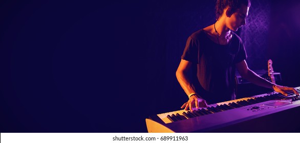 Confident male musician playing piano in nightclub - Powered by Shutterstock