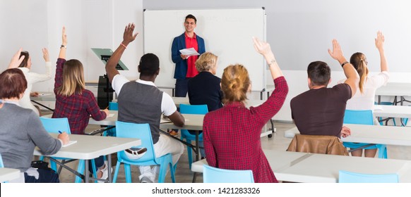 Zuversichtliche männliche Studentin, die vor der Gruppe der Schüler im Auditorium auf Whiteboard antworten