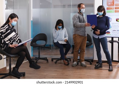 Confident Man Handing Over To Pregnant Manager CV Resume While Talking About Job Experience In Waiting Room. Cultural Diverse People In Lobby Area Reading Duties Sheet And Company Internal Regulations