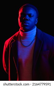 Confident Man. Serious Face. Neon Light Portrait. Stylish Handsome Cyberpunk Guy In Colorful Red Blue Glow Isolated On Black Background.