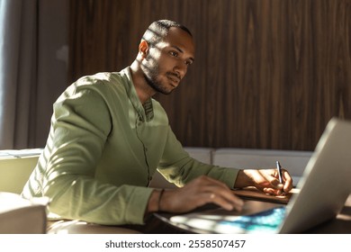 Confident man using laptop while working in office