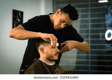 Confident man visiting hairstylist in barber shop.Hairdresser cutting hair in an Argentinian barber shop. - Powered by Shutterstock