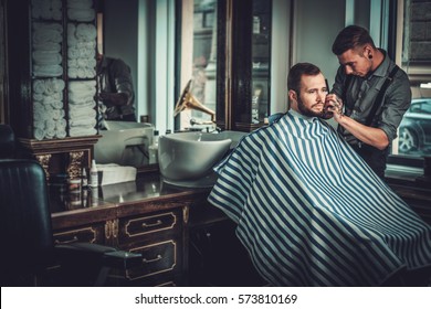 Confident Man Visiting Hairstylist In Barber Shop