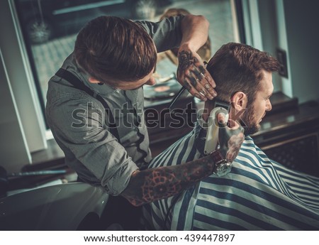Confident man visiting hairstylist in barber shop.