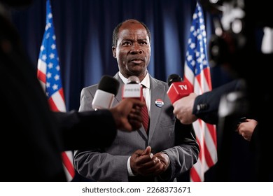 Confident mature African American politician in formalwear asking questions of journalists while speaking in microphones - Shutterstock ID 2268373671