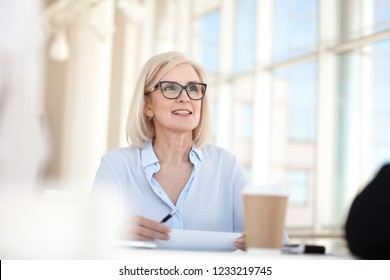 Confident Mature Business Woman Leader Coach Speaking At Meeting Negotiations, Old Middle Aged Female Manager Executive Mentor Talking Participating In Discussion At Office Conference Briefing