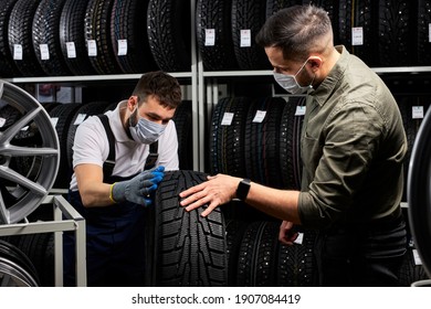 Confident Mechanic In Mask And Client Checking Tires In Store, Having Conversation In Shop, Customer Is Going To Make Purchase