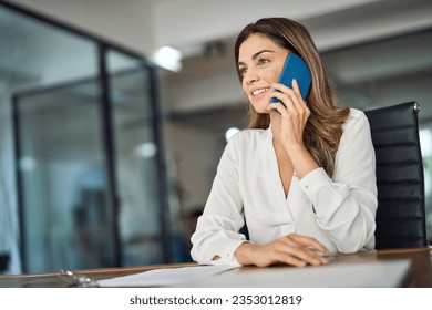 Confident mid aged business woman executive making business call in office. Smiling mature 40s female professional executive manager, lawyer or entrepreneur talking on cell phone at workplace. - Powered by Shutterstock