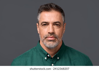 Confident middle aged business man entrepreneur, unsmiling mature professional executive manager, businessman leader investor wearing green shirt isolated on gray, headshot close up portrait. - Powered by Shutterstock