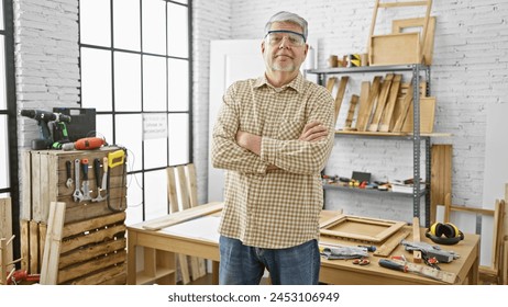 Confident middle-aged man with arms crossed stands in a well-equipped carpentry workshop, portraying craftsmanship and expertise. - Powered by Shutterstock