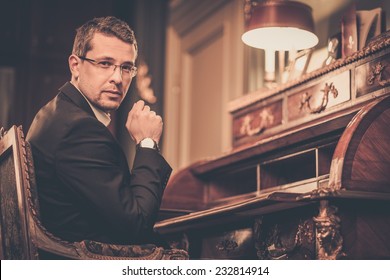 Confident middle-aged man in luxury vintage style interior 