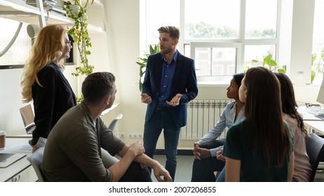 Confident millennial business leader, presenter speaking before team of employees on corporate meeting, presenting ideas, solutions for project. Business coach, mentor training staff, giving workshop - Powered by Shutterstock