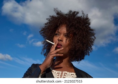 Confident modern black woman smoking a cigarette - Powered by Shutterstock