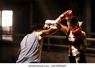 Confident Muay Thai boxer woman training boxing with trainer  - Powered by Shutterstock