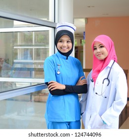 Confident Muslim Female Doctor And Nurse In Head Scarf Smile