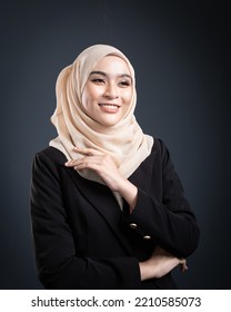 Confident Muslim Woman Wearing Hijab Poses Strongly And Confidently. Women Empowerment And Leadership Concept. Isolated On Dark Background