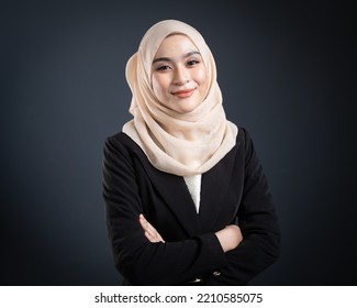 Confident Muslim Woman Wearing Hijab Poses Strongly And Confidently. Women Empowerment And Leadership Concept. Isolated On Dark Background