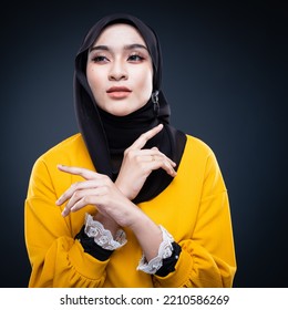 Confident Muslim Woman Wearing Hijab Poses Strongly And Confidently. Women Empowerment And Leadership Concept. Isolated On Dark Background