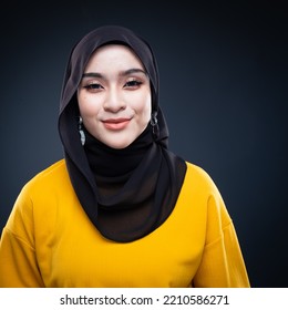 Confident Muslim Woman Wearing Hijab Poses Strongly And Confidently. Women Empowerment And Leadership Concept. Isolated On Dark Background