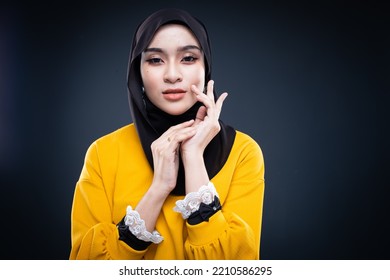 Confident Muslim Woman Wearing Hijab Poses Strongly And Confidently. Women Empowerment And Leadership Concept. Isolated On Dark Background