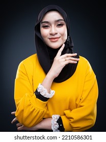 Confident Muslim Woman Wearing Hijab Poses Strongly And Confidently. Women Empowerment And Leadership Concept. Isolated On Dark Background
