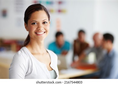 Confident in my teams abilities. Portrait of a positive-looking young professional with her colleagues working in the background. - Shutterstock ID 2167544803