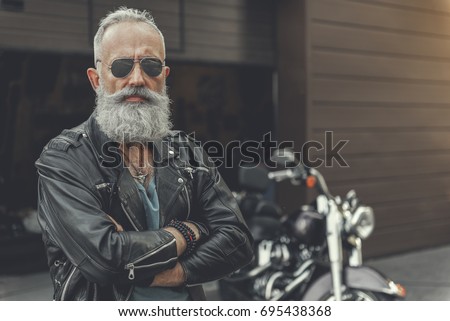 Confident old man having rest near bike