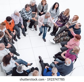 Confident Older Woman Standing In A Circle Of Like-minded People