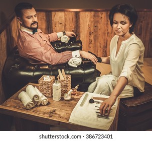 Confident Old-fashioned Man Doing Male Manicure In A Barber Shop. 