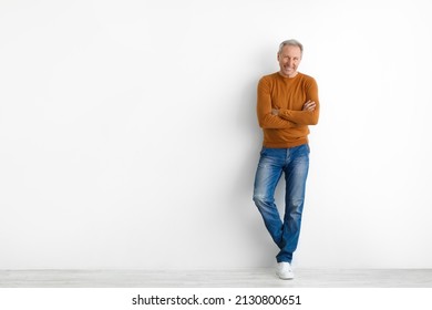 Confident Person. Portrait Of Cheerful Casual Senior Man Posing With Folded Arms Standing Isolated Over White Studio Background Leaning On Wall With Crossed Hands. Male Adult Smiling Looking At Camera