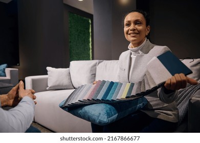 Confident Pleasant African American Woman, Interior Designer Sales Manager In Furniture Showroom Holding Colorful Fabric Samples For Soft Furniture Upholstery And Renovation. Home Design Project
