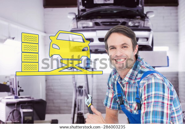 Confident plumber holding adjustable wrench against\
auto repair shop