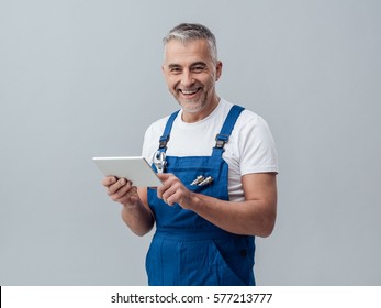 Confident Plumber Or Mechanic Connecting With A Digital Tablet And Using Apps