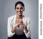 Confident, portrait or businesswoman in studio with smile, mission or hands clasped on gray background. Elegance, female empowerment or proud Indian recruiter with hiring opportunity for employment