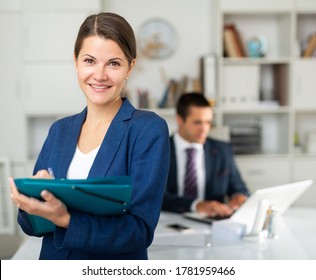 Confident positive businesswoman holding folder with papers, writing tasks and instructions 