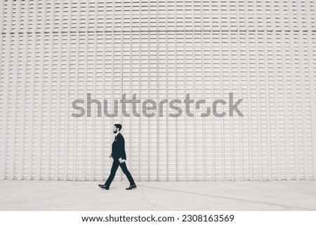 Confident and professional elegant bearded businessman walking outdoor strong and trusty