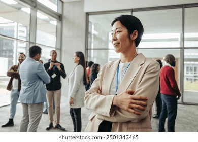 Confident professional woman in the office environment, engaging in networking and social interaction with colleagues, showcasing a modern workplace setting. - Powered by Shutterstock