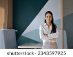 Confident professional young latin business woman company employee, lady executive manager, female worker or entrepreneur looking at camera standing arms crossed in modern office, portrait.