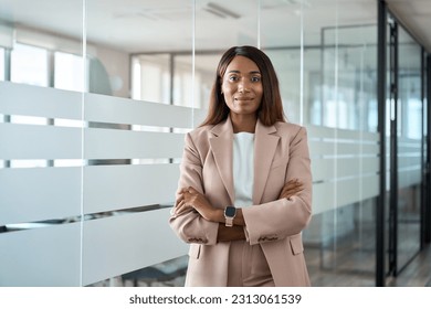 Confident proud young professional business woman ceo, female corporate executive leader, African American lady lawyer wearing suit standing arms crossed in office near glass wall, portrait. - Shutterstock ID 2313061539